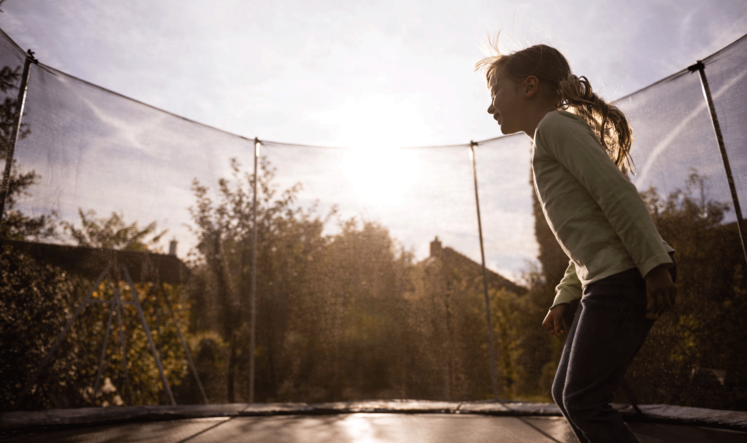 Trampoline kopen voor jarenlang veilig springplezier Meisje springt op veilige trampoline in de tuin